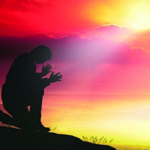 Silhouette human kneeling and praying over over beautiful sunset background. World Mental Health Day, Worship, Forgiveness, Mercy, Humble, Repentance, Reconcile, Adoration, Glorify concept.