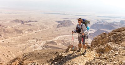 A man standing with backpacking gear on the Israel National Trail